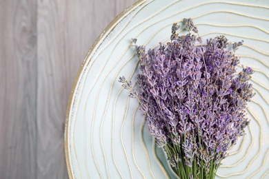 Photo of Beautiful blooming lavender flowers on plate, top view