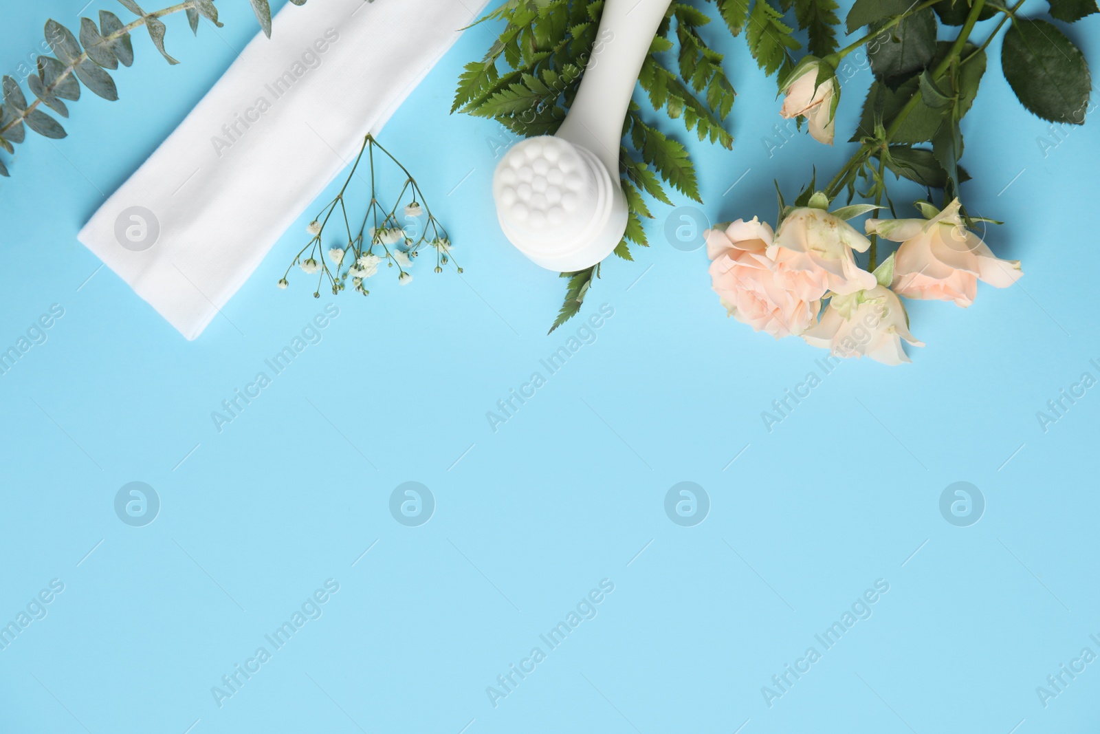 Photo of Flat lay composition with face cleansing brush on light blue background, space for text. Cosmetic accessory