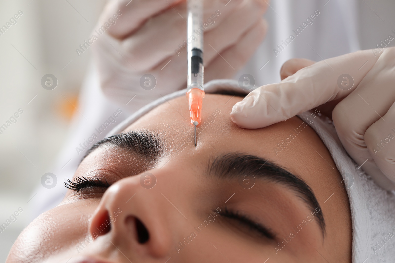 Photo of Doctor giving facial injection to young woman in clinic, closeup. Cosmetic surgery