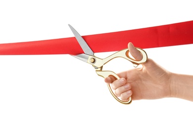 Woman cutting red ribbon on white background