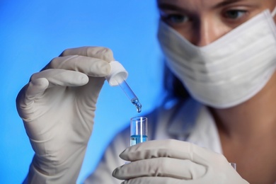 Scientist dripping reagent into test tube with sample, closeup. Laboratory analysis