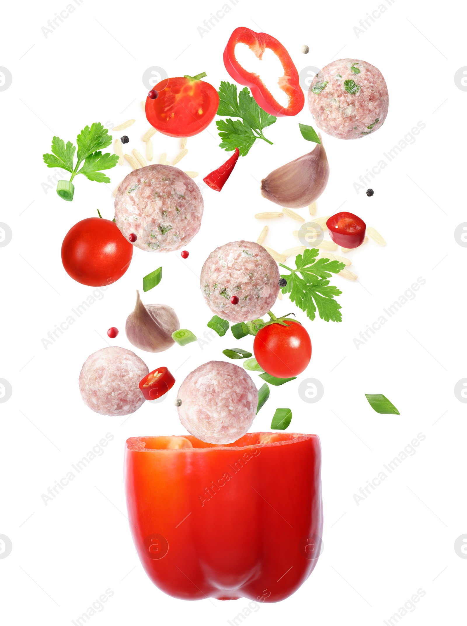 Image of Stuffed pepper recipe. Fresh ingredients falling into bell pepper on white background