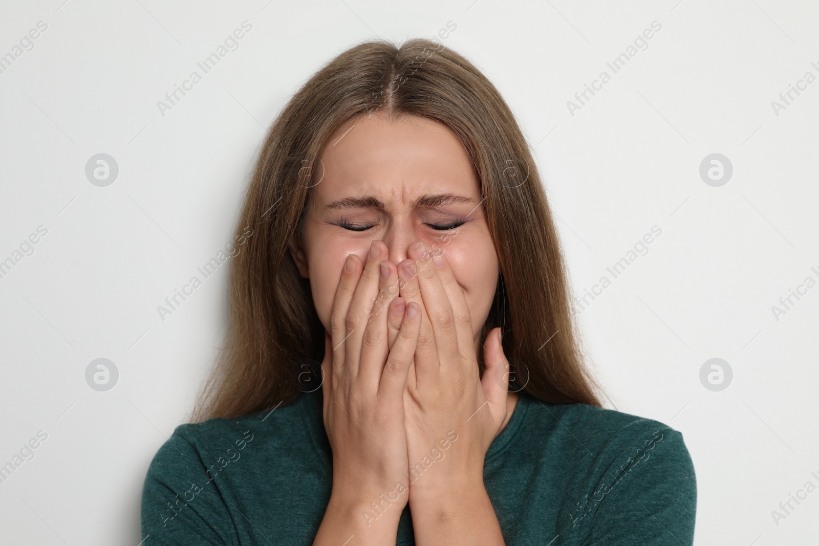Photo of Portrait of crying young woman on light background. Stop violence