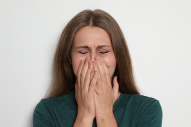 Portrait of crying young woman on light background. Stop violence