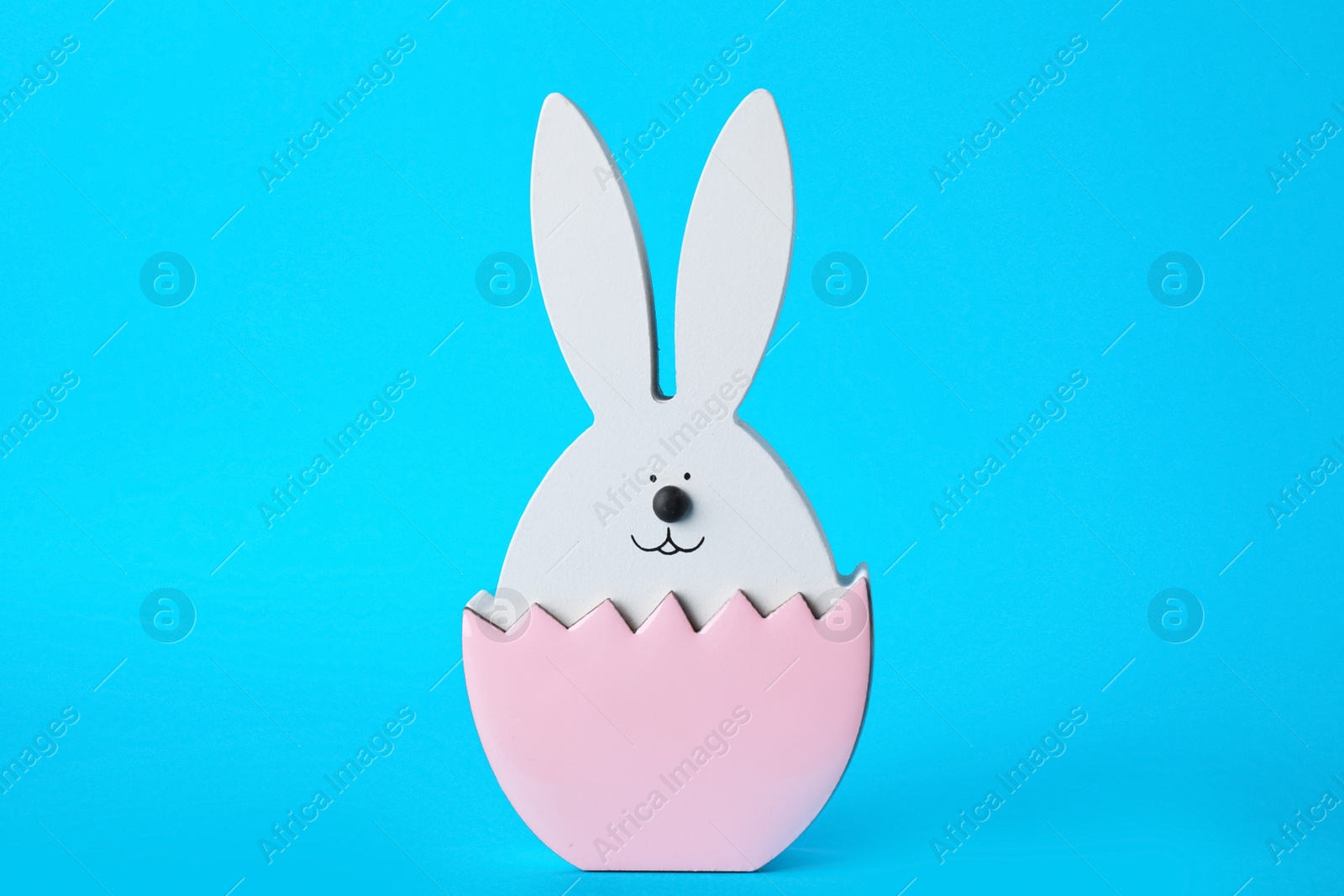 Photo of Bunny figure as Easter decor on blue background