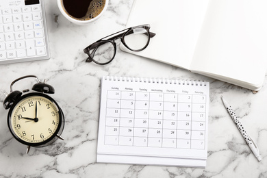 Photo of Flat lay composition with calendar and cup of coffee on white marble table