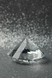 Photo of Beautiful dazzling diamond on shiny glitter background. Precious gemstone