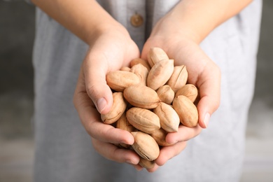 Photo of Woman holding pecan nuts in hands, closeup