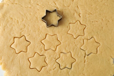 Making shortcrust pastry. Raw dough and cookie cutter on table, top view