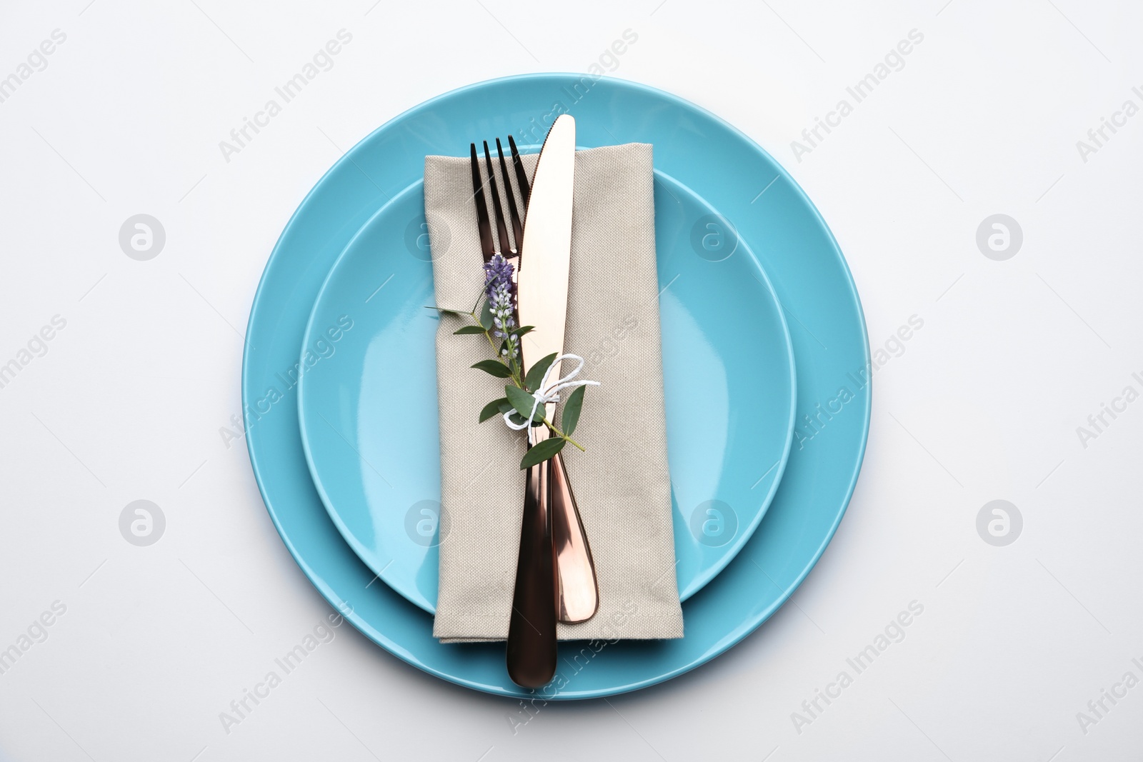 Photo of Stylish elegant cutlery with napkin and floral decor in plate on white background, top view