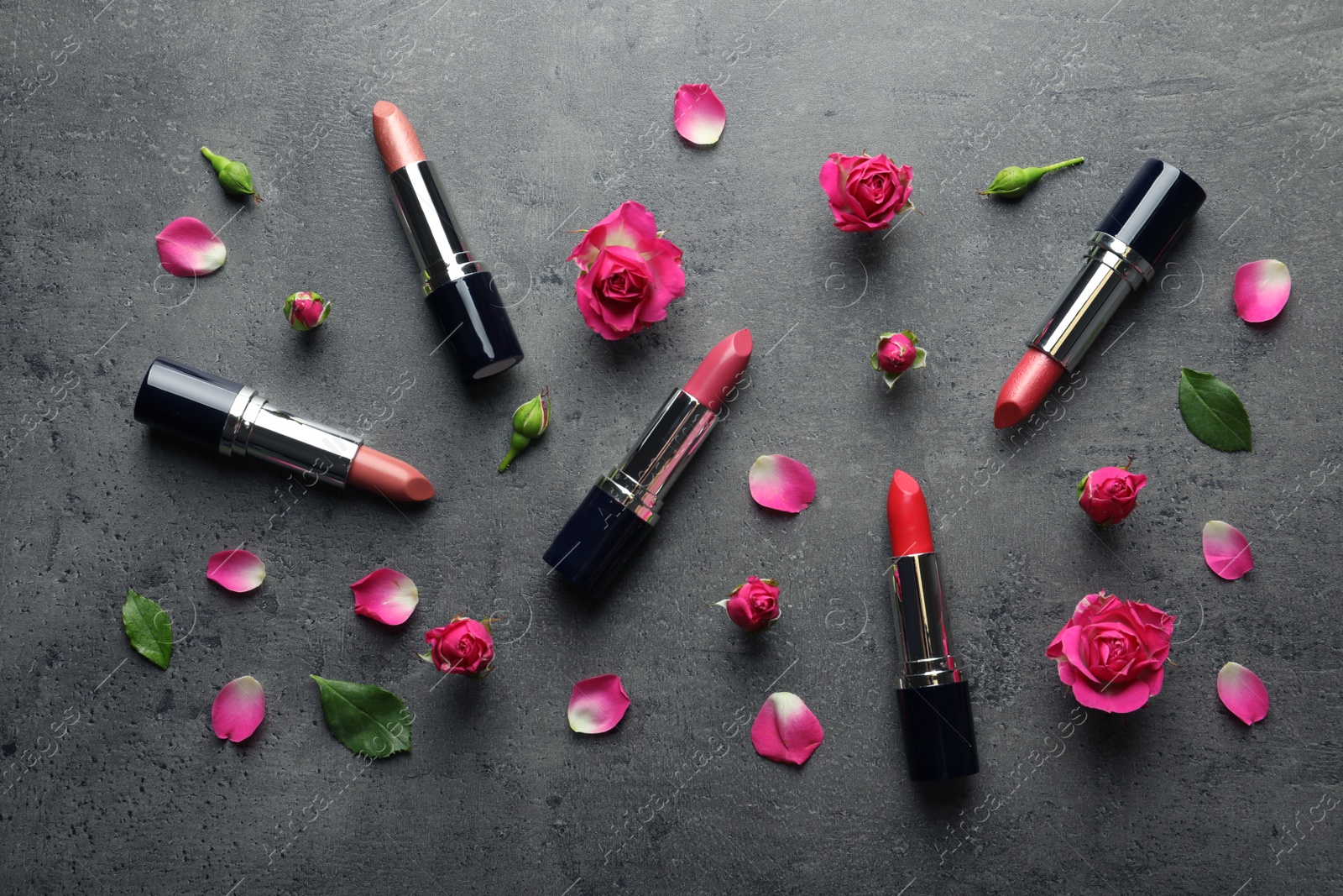 Photo of Flat lay composition with lipsticks and roses on grey background