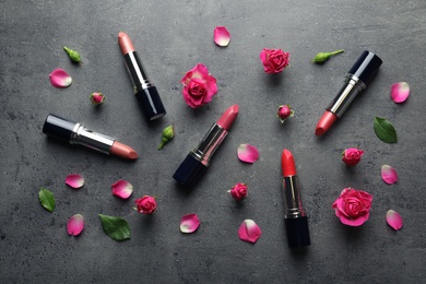 Flat lay composition with lipsticks and roses on grey background