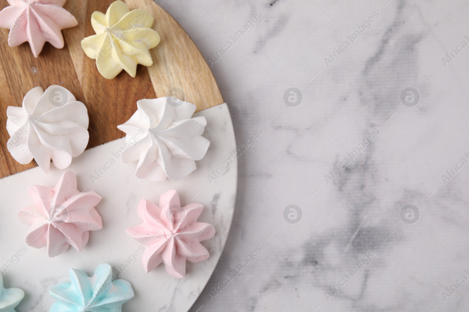 Photo of Tray with tasty meringue cookies on white marble table, top view. Space for text