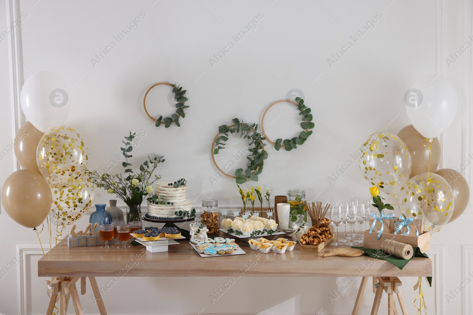 Photo of Beautiful cake and other treats on table in room. Baby shower party