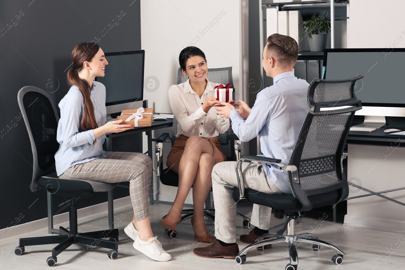 Photo of Colleagues presenting gifts to man in office