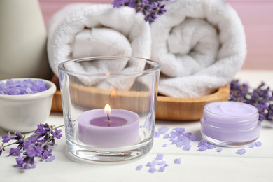Photo of Cosmetic products and lavender flowers on white wooden table, closeup