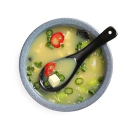 Photo of Bowl of delicious miso soup with tofu and spoon isolated on white, top view