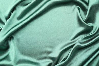 Photo of Crumpled green silk fabric as background, top view