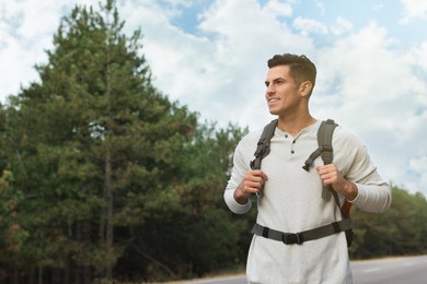 Photo of Happy man with backpack on road near forest