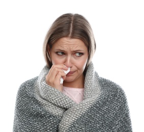 Photo of Young woman wrapped in warm blanket suffering from cold on white background