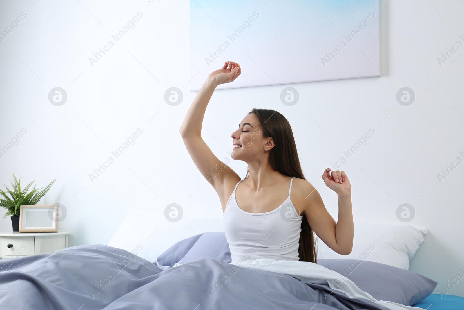 Photo of Young woman stretching at home in morning. Bedtime