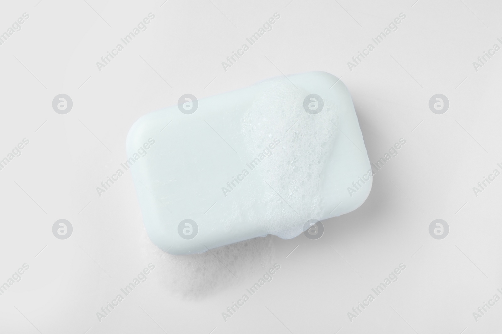 Photo of Soap with fluffy foam on white background, top view