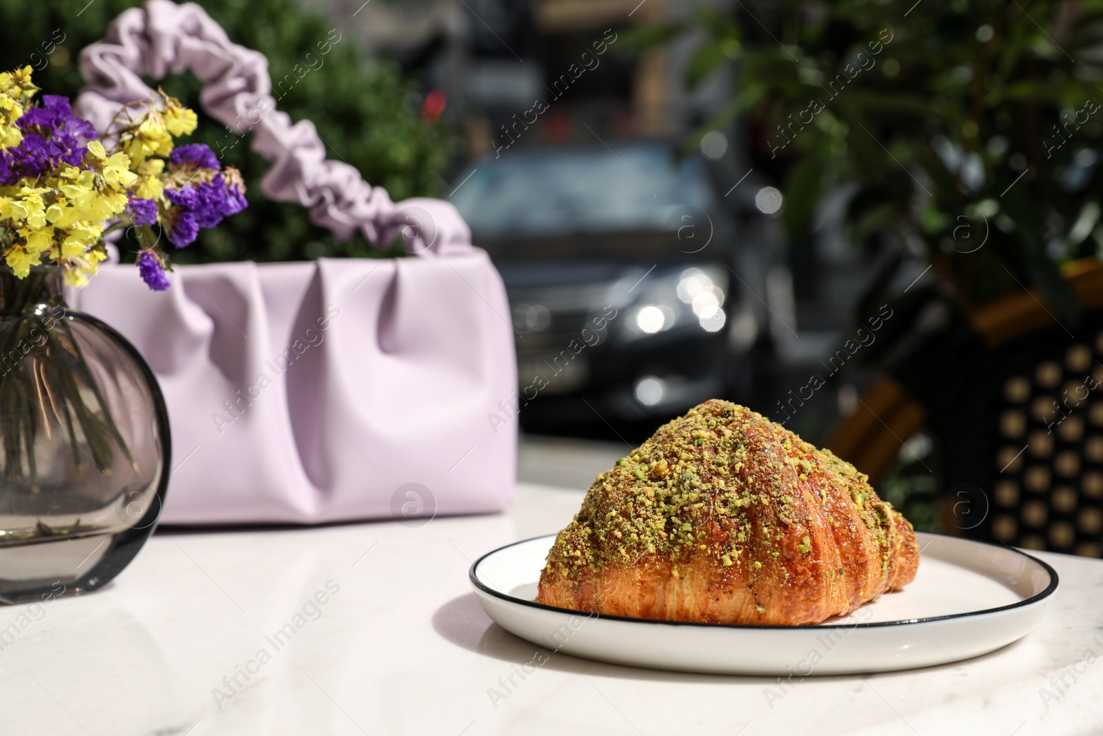 Photo of Delicious croissant and bag on white table