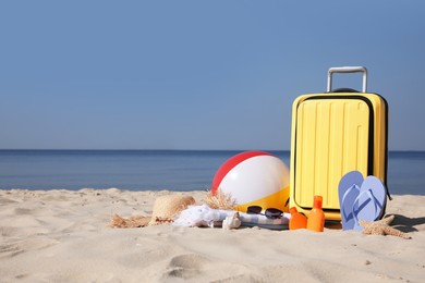 Photo of Suitcase and beach accessories on seaside. Space for text