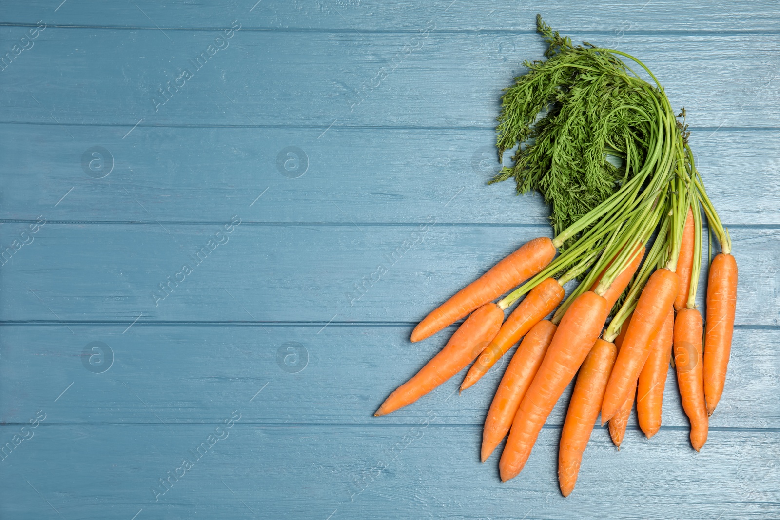 Photo of Ripe carrots on wooden background, top view