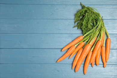 Photo of Ripe carrots on wooden background, top view