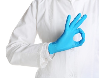 Photo of Doctor in medical glove showing OK gesture on white background