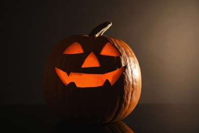 Photo of Halloween pumpkin head. Glowing jack lantern on dark background