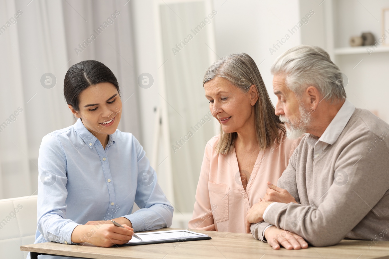 Photo of Notary showing senior couple where to sign Last Will and Testament in office