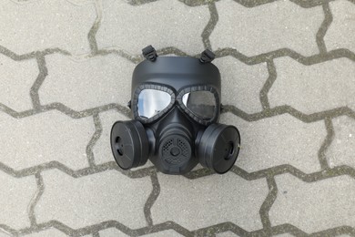 One gas mask on paved pathway outdoors, top view