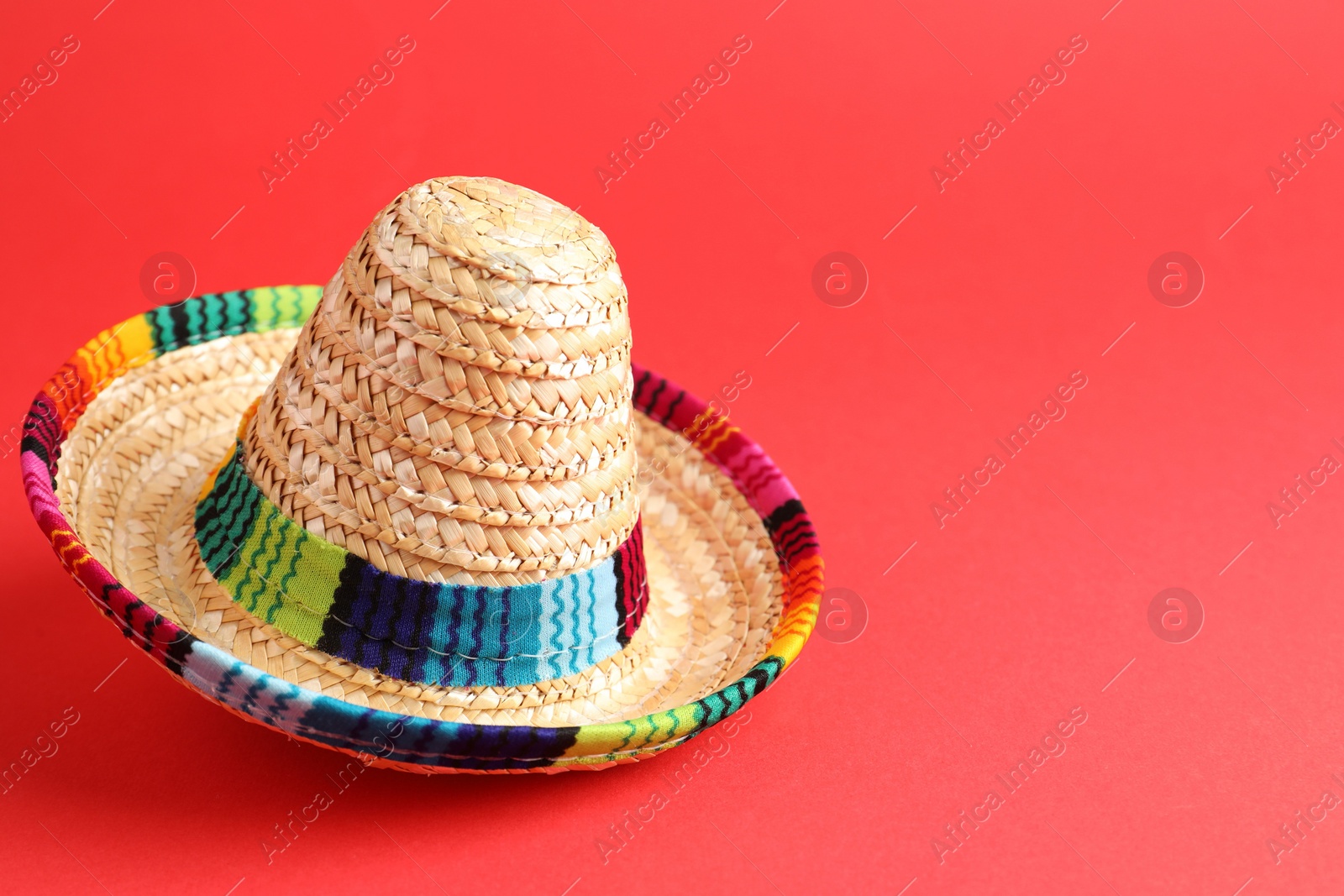 Photo of One Mexican sombrero hat on red background. Space for text