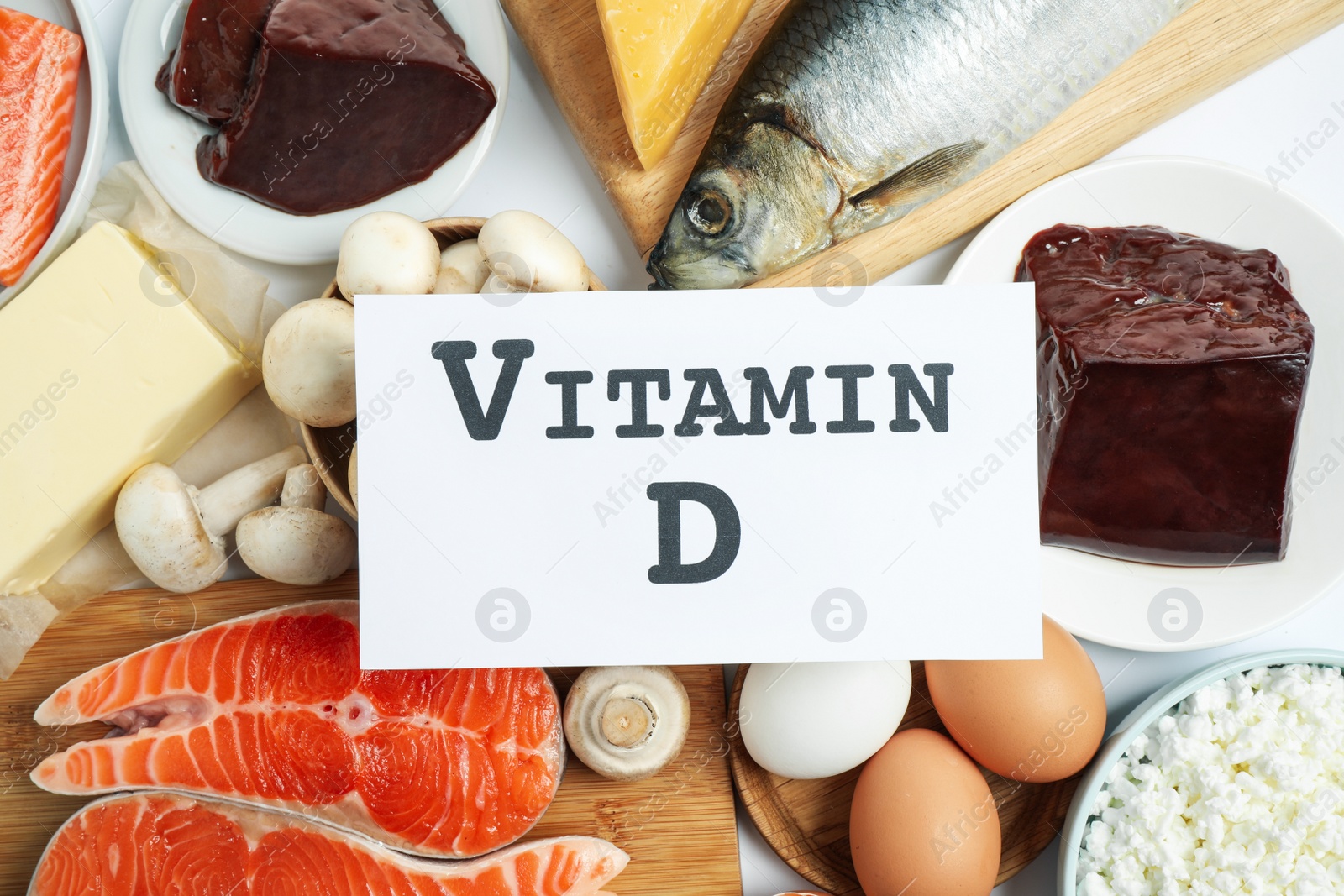 Photo of Paper with phrase VITAMIN D and fresh products on white background