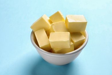 Bowl with fresh butter on color background