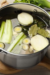 Different ingredients for cooking tasty bouillon in pot on table, closeup