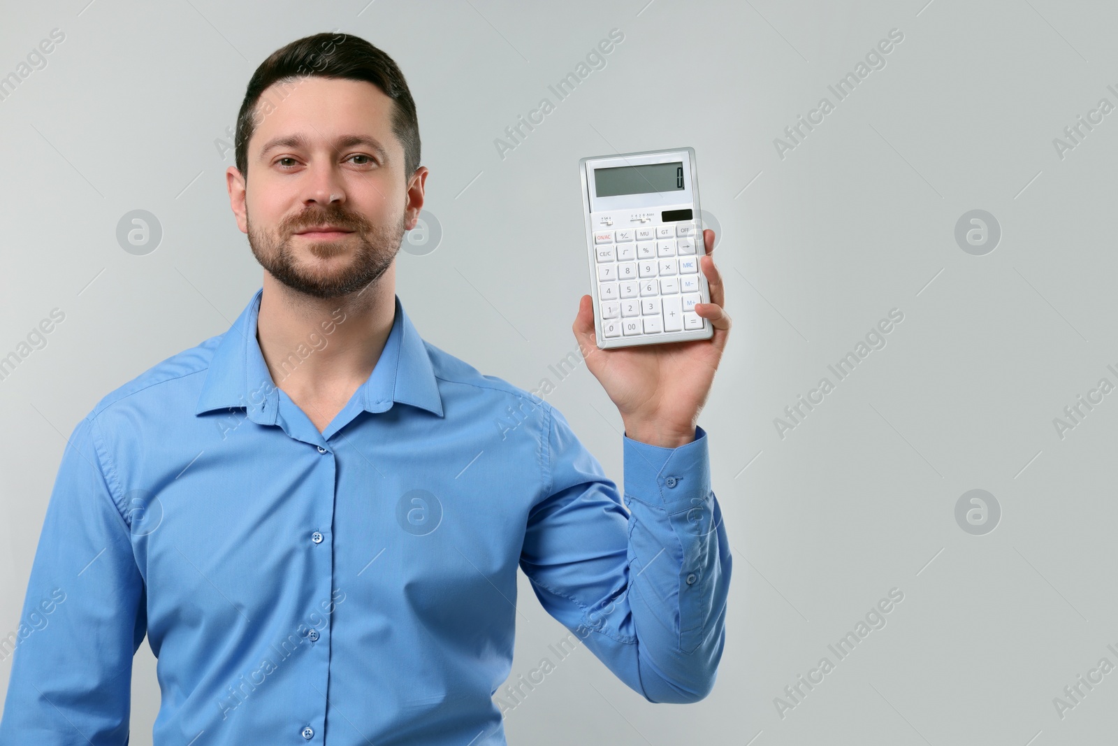 Photo of Accountant showing calculator on light grey background. Space for text