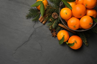 Photo of Christmas composition with tangerines on black background, flat lay. Space for text