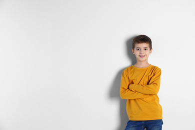 Photo of Portrait of cute little boy on light background, space for text