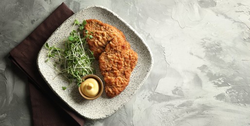 Image of Tasty schnitzels served on grey textured table, top view. Banner design with space for text