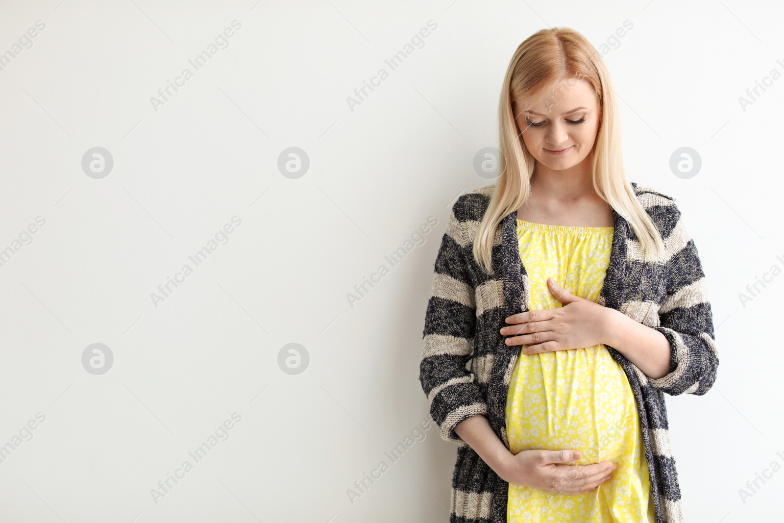 Photo of Portrait of beautiful pregnant woman on light background. Space for text