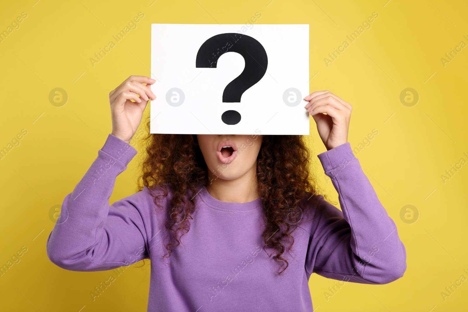 Photo of African-American woman with question mark sign on yellow background
