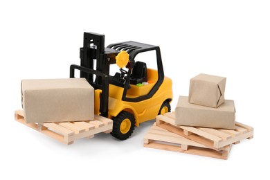 Photo of Toy forklift, wooden pallets and boxes on white background