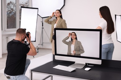 Photo of Professional photographer and assistant working with beautiful model in modern photo studio, selective focus