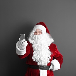 Authentic Santa Claus taking selfie on grey background. Space for text