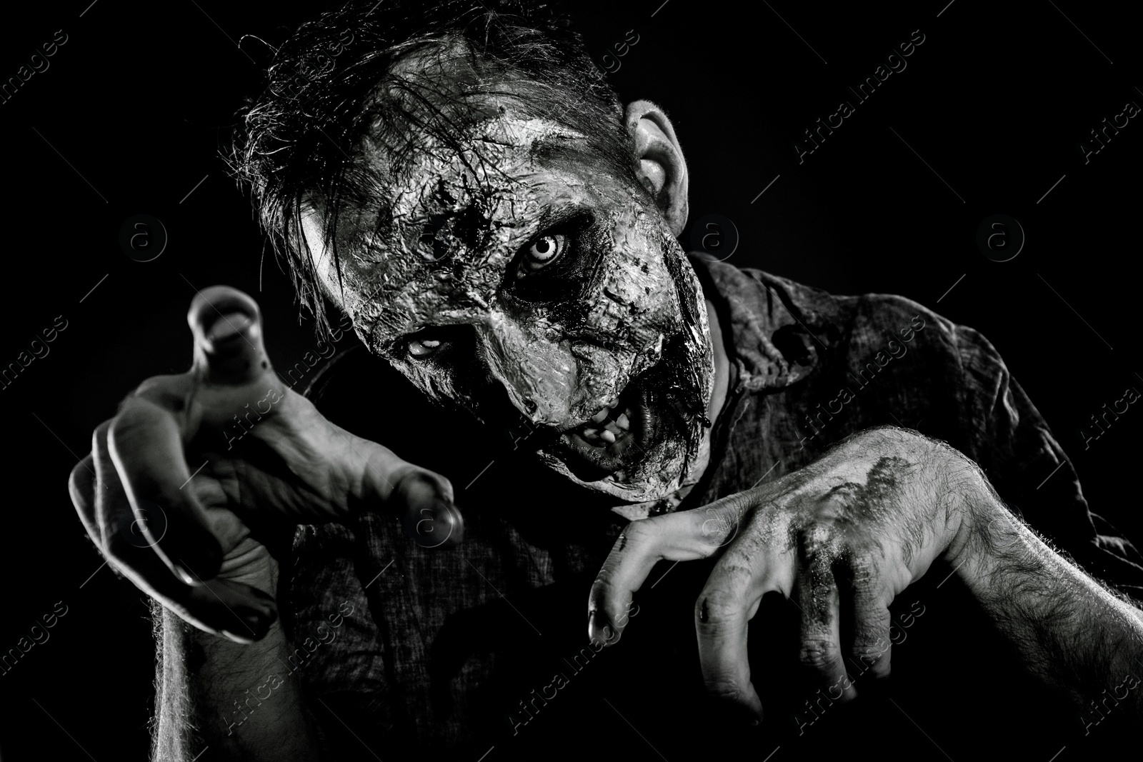 Photo of Scary zombie on dark background, black and white effect. Halloween monster