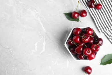 Flat lay composition with ripe sweet cherries on marble table. Space for text