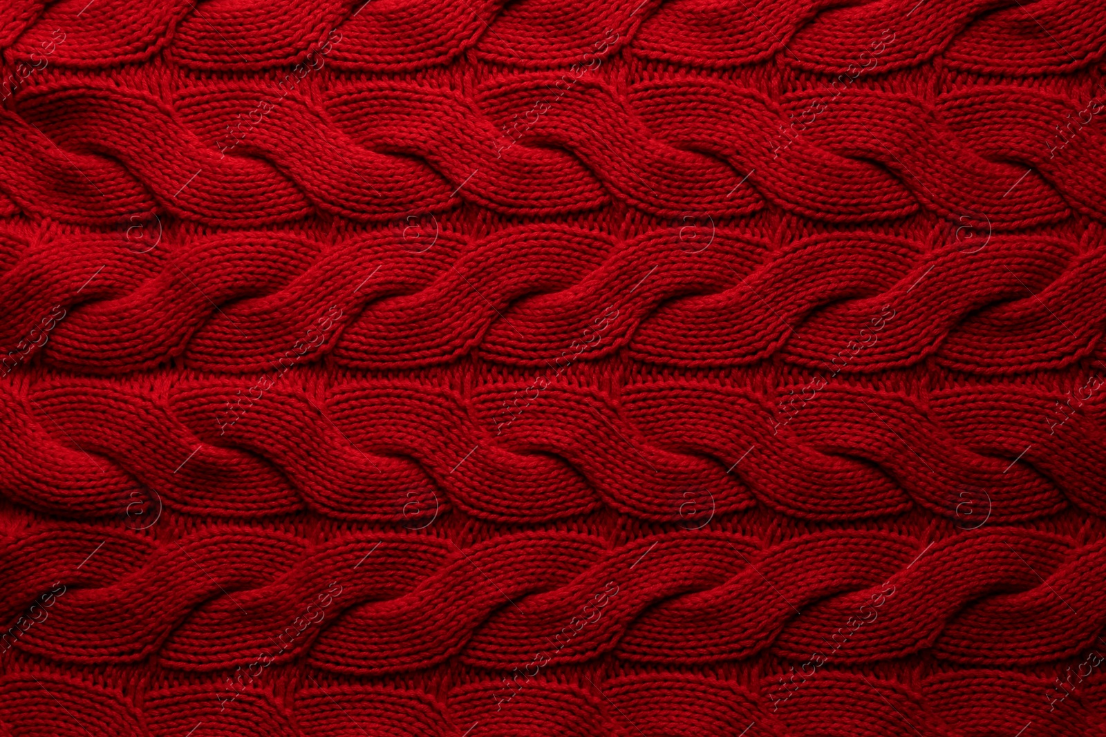 Photo of Beautiful red knitted fabric as background, top view